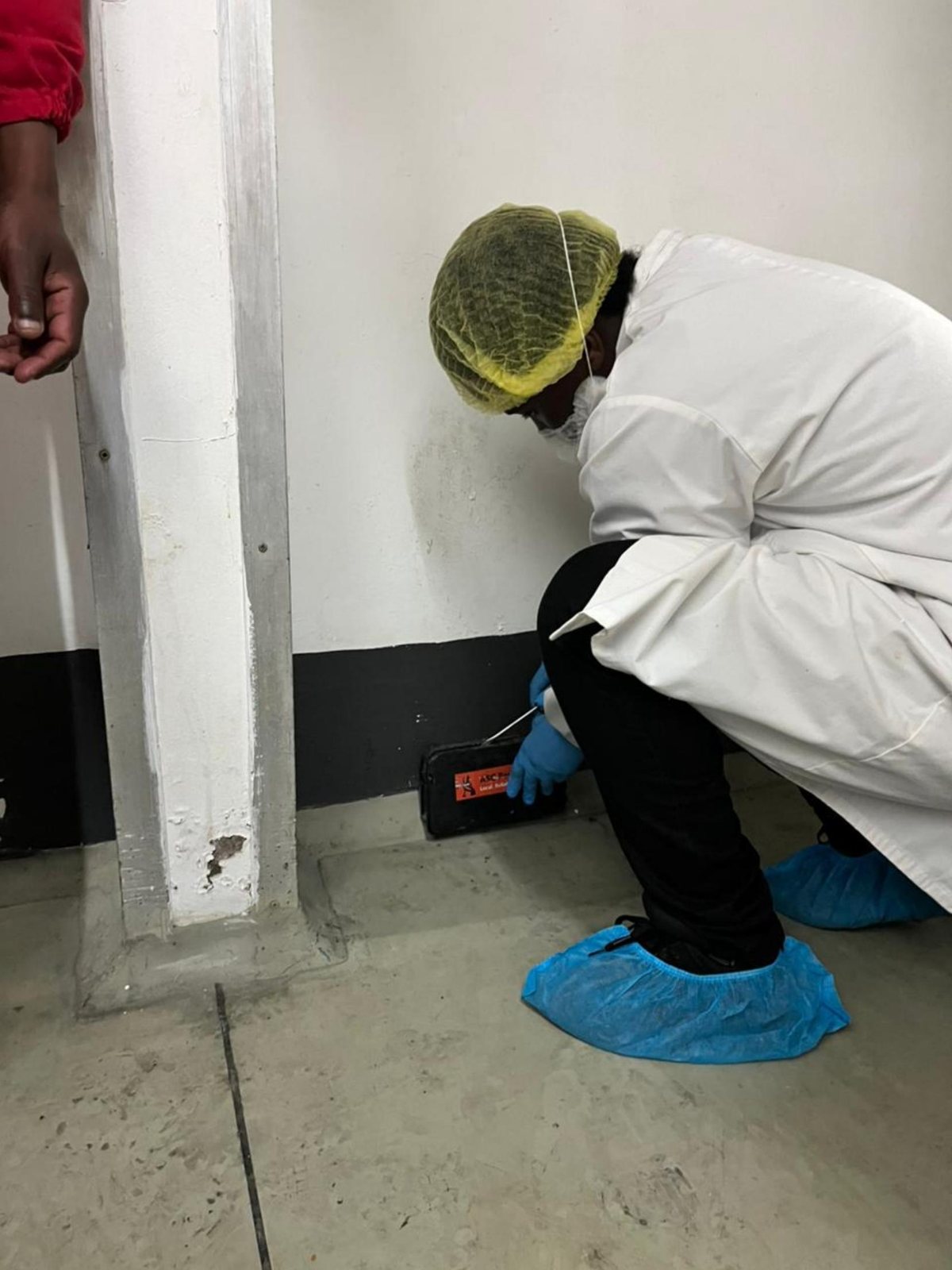 ASC Pest Control technician taking a verification swab near a monitoring point